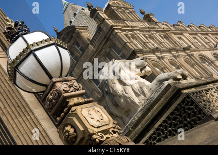 A carved lion on a plinth and ornate lamp outside Leeds Town Hall on The Headrow, the main street in Leeds City Centre. Stock Photo
