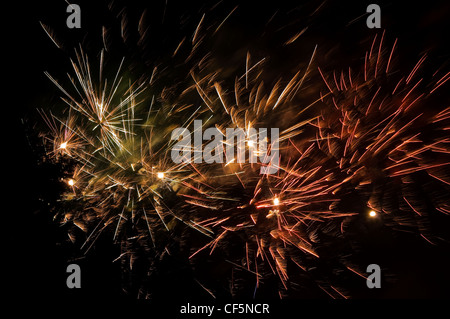 Spectacular trails of light from fireworks exploding in the evening sky on bonfire night. Stock Photo