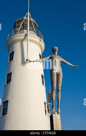 The Diving Belle sculpture representing Scarborough of the present by Craig Knowles next to Scarborough Lighthouse on Vincent Pi Stock Photo