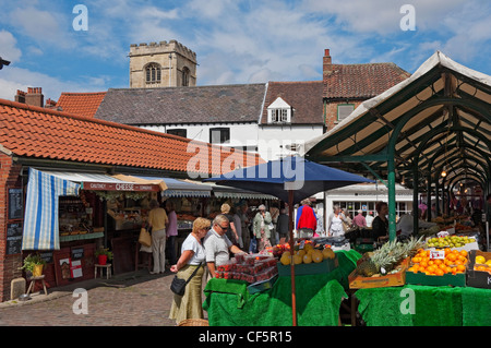 People buying from market stalls at York open air market. Stock Photo