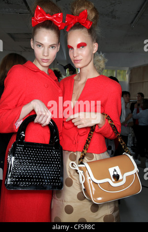 Luella Backstage London Ready to Wear Spring Summer A bright red double breasted coat dress a bright red patent bow in her Stock Photo