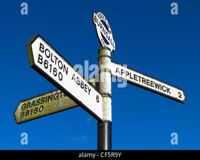 Road sign at Burnsall showing directions to Grassington, Bolton Abbey and Appletreewick. Stock Photo