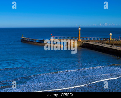 Waves rolling into land off the North sea past the West Pier and East Pier at the entrance to Whitby Harbour. Stock Photo