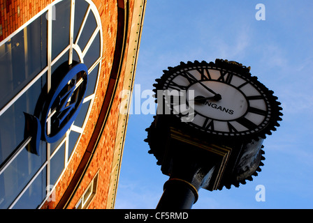 A clock face and shop exterior at St Patrick's Street in Cork. Stock Photo