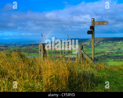 Rainbow above signpost and gate on the Cleveland Way near Sutton Bank in the North York Moors National Park. Stock Photo