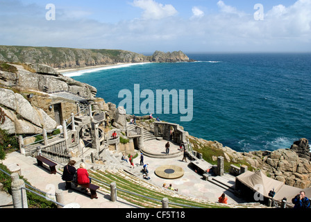 A view down over the steep seating and stage at the Minack Theatre towards Porthcurno Bay and Logan Rock in the background. Stock Photo