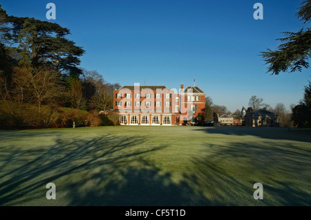 View across the cedar lawn to Woodcote Park, one of two clubhouses that belong to the Royal Automobile Club, a private members c Stock Photo