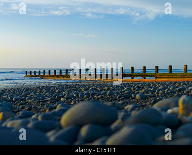 Low view over pebbles towards a groyne on the beach at Borth by the Irish Sea. Stock Photo
