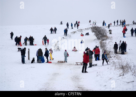 Crowd of people playing in the Snow on the Epsom Downs near the Rubbing House Pub. Stock Photo