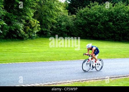 A triathlete cycling out on the course during a triathlon event at Eton Dorney, an Olympic venue for the London 2012 Games. Stock Photo