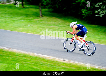 A triathlete cycling out on the course during a triathlon event at Eton Dorney, an Olympic venue for the London 2012 Games. Stock Photo