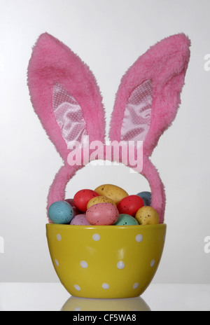 Easter eggs in a polka dot bowl, with pink rabbit ears Stock Photo