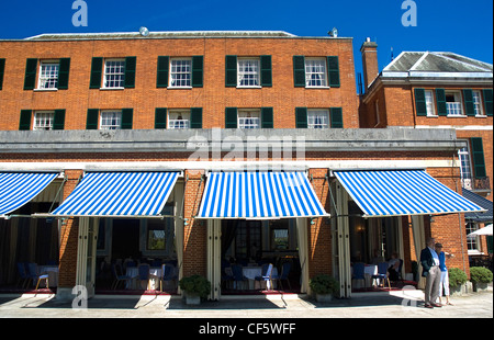 A couple standing on a terrace outside a restaurant at Woodcote Park, a private members club on the North downs owned by the Roy Stock Photo