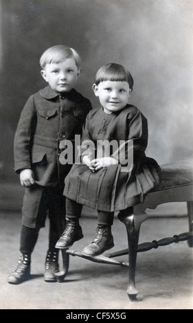 Siblings posing for a photograph, circa 1910. Stock Photo