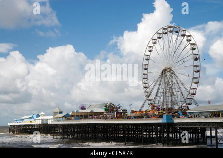 Seaside view in summer of a pier with pleasure rides at Blackpool. The town is believed to get its name from a drainage channel Stock Photo