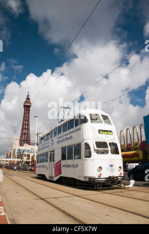 Tram running along a seafront on a sunny summer day at Blackpool. The town is believed to get its name from a drainage channel w Stock Photo