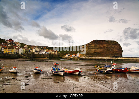 Fishing boats in Staithes harbour at low tide. Stock Photo