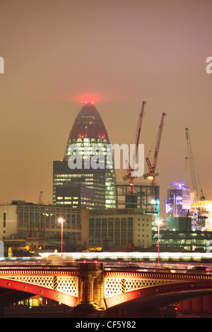 View of the City of London at night from the South Bank of the Thames featuring one of London's most famous landmarks 30 St. Mar Stock Photo