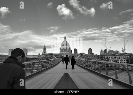 People walking across the Millennium Footbridge towards St Pauls Cathedral. Stock Photo