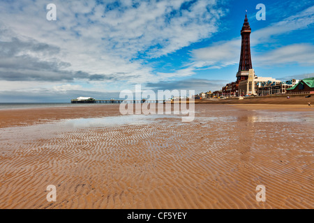 A view across the sandy beach towards Blackpool tower and North Pier on a summers day. Stock Photo