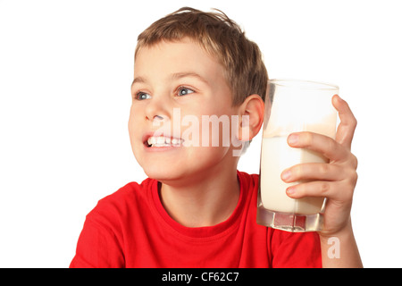 little boy in red sports shirt laughs and holds container of milk in hand Stock Photo