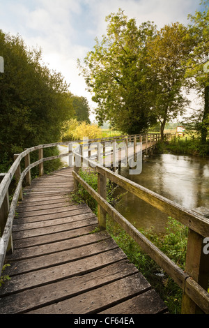 A wooden footbridge over the River Test leading to Chilbolton Cow Common. Stock Photo