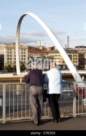 Millennium Bridge and Newcastle Quayside with onlookers. This foot and cycle bridge was opened in 2001 and won the Royal Institu Stock Photo