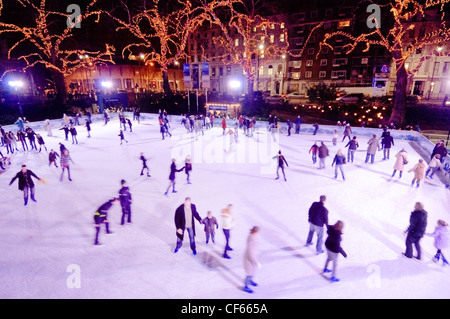 People enjoying an ice skating rink outside the Natural History Museum. Stock Photo