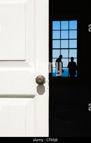 Looking through a doorway to two figures silhouetted against a window inside Mussenden Temple. Stock Photo