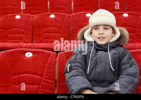 Boy sits in expectation of  hockey match Stock Photo