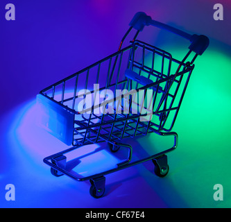 Studio shot of shopping cart in abstract multicolor light. Stock Photo