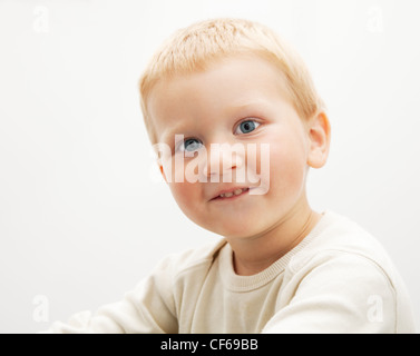Portrait of a cute blond boy photographed on light background