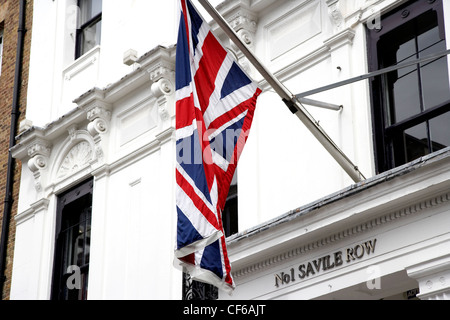 A Union Jack flag hangs above the entrance to number 1 Saville Row in London. Stock Photo