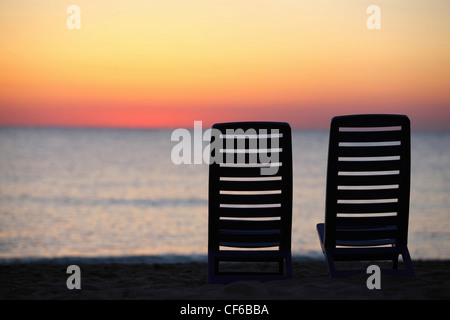 In  evening at  seaside two plastic chairs cost in  evening during sunset Stock Photo