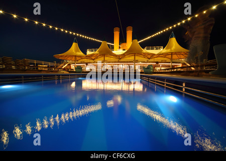 illuminated deck of ship at evening. swimming pool in deck of ship Stock Photo