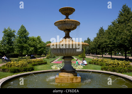 People sitting by a fountain in Regent's Park. Stock Photo
