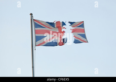 Torn Union Jack. Ripped UK flag in two pieces with one section flying away, suggesting an independence, devolution or Brexit concept Stock Photo