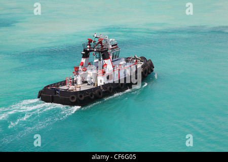 Pilot on little fire pusher tug drift through the sea at day Stock Photo