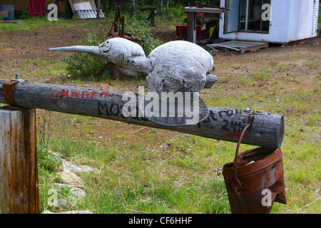 Wood carving of a mosquito on a hitching  post Stock Photo