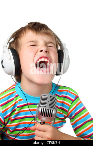Little boy in headphone with microphone in hands sings with wide open mouth Stock Photo