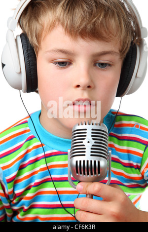 Little cheerful boy in headphone with microphone in hands opened slightly mouth  on a white background Stock Photo