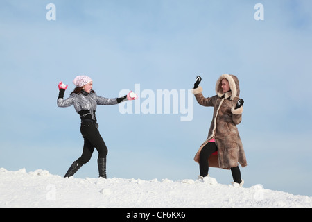 Two girls play snowballs and laugh Stock Photo