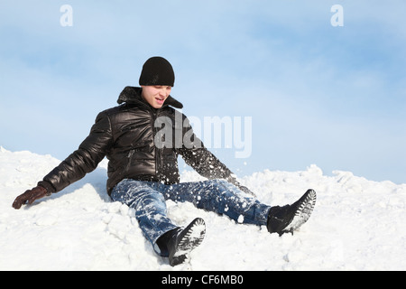 Youth sits in winter on snow and throws him up Stock Photo