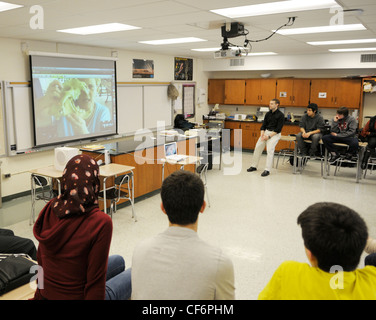 Classroom of American students video conferencing with a researcher at a field station in Panama - showing them a jaguar skull. Stock Photo