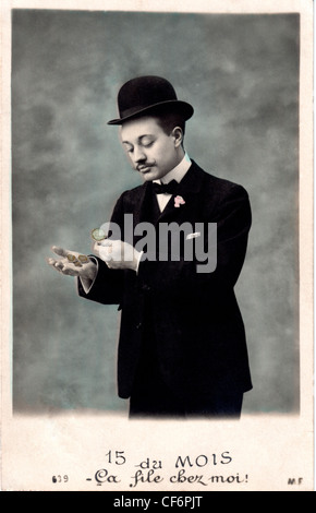 A vintage photo of a man wearing a suit and top hat counting his money, circa 1907. Stock Photo