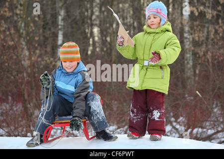 Brother and sister intend  drive from  hill in winter on sledges Stock Photo