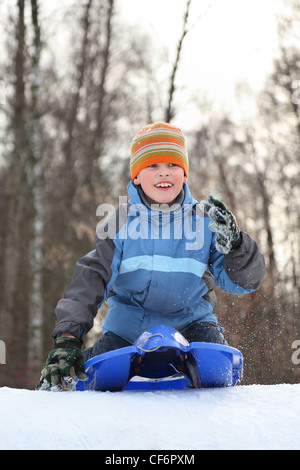 Boy intend  drive from  hill in winter on sledges and looks ahead Stock Photo