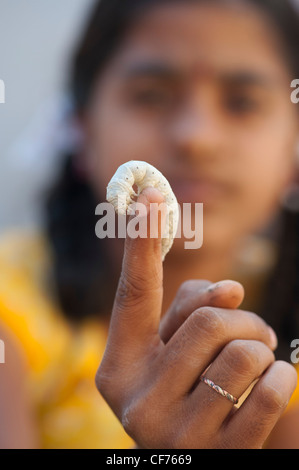 Indian girl with silkworm on her finger. Andhra Pradesh, India Stock Photo