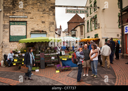 UK, Gloucestershire, Stroud, Swan Lane, farmer’s market below Swan Inn’s sign over the road Stock Photo