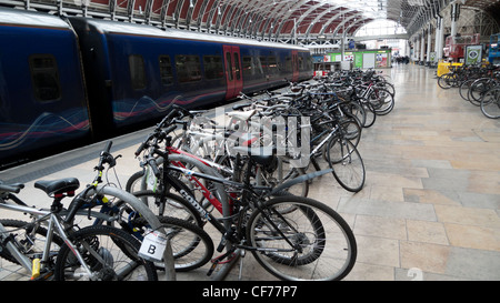 Bikes stored on a temporary bicycle stand on the train platform at Paddington Station London England UK Stock Photo